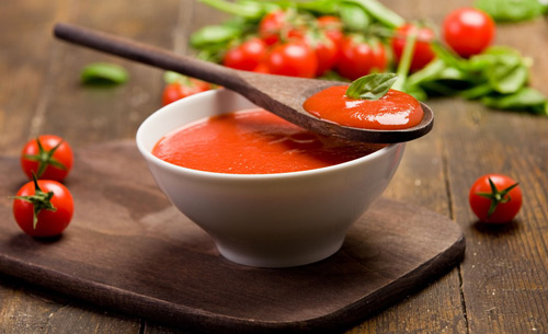 Tomato Soup in bowl with wooden spoon
